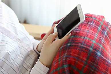 スマホを手に取る女性